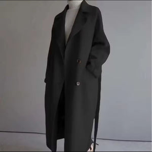 Black coat on a mannequin against a plain background